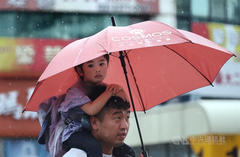 圖為台北市萬華區午後出現短暫陣雨,民眾走在路上撐起雨傘。(中央社檔案照片)