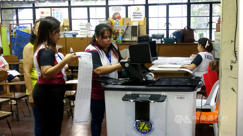 菲律賓12日舉行期中選舉,改選參議院24席中的12席,並選出300多名眾議員,以及各省市鎮地方首長和地方議員。圖為馬尼拉一投票所內,選務人員協助選民將填好的選票投入計票機。中央社記者林行健馬尼拉攝 114年5月12日